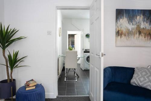 een woonkamer met een blauwe bank en een tafel bij *Central 2 bed - Sleeps 5* in Chesterfield