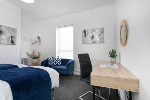 1 dormitorio con 1 cama, 1 mesa y 1 silla azul en *Central 2 bed - Sleeps 5* en Chesterfield