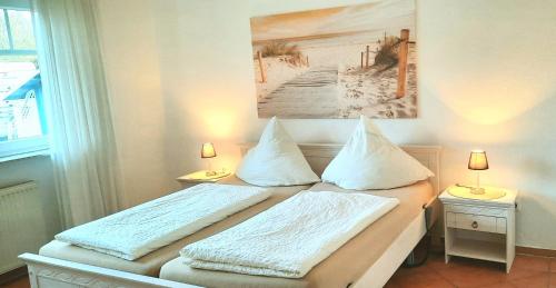 ヴェルドゥムにあるAm Osthörn rollstuhlgerechtのベッドルーム1室(枕2つ、絵画付)