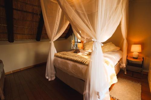 a bedroom with a canopy bed with curtains at Bushveld Jewel - Close to Kruger in Hoedspruit