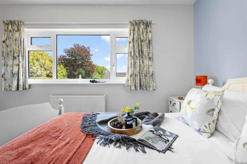 a bedroom with a bed and two windows at The Old Orchard in Dartmouth