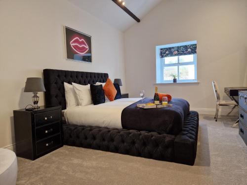 a bedroom with a bed with a black leather couch at 7 Holly Barn in Preston