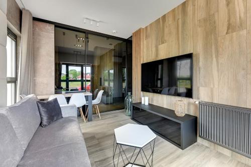 a living room with a couch and a tv at GRANO FLATS - Sobieszewo - Baltic Porto in Gdańsk