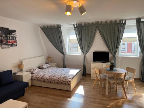 a bedroom with a bed and a table and a couch at Grand Central Apartments in Katowice