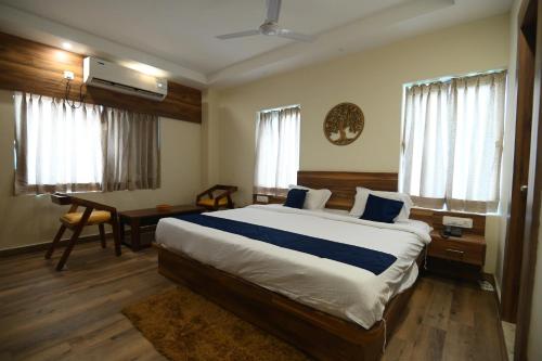a bedroom with a large bed and a desk with a computer at Namastey Puri in Puri