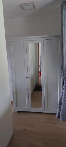 a white cabinet with mirrored doors in a room at Chataa in Szczechy Małe