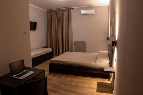 een kleine kamer met een bed en een bureau met een laptop bij Santé in San Nicandro Garganico
