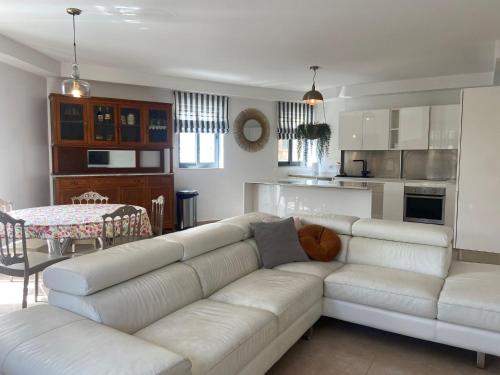 sala de estar con sofá blanco y cocina en Cozy 2 bedroom Apartment near Seafront en Il-Gżira