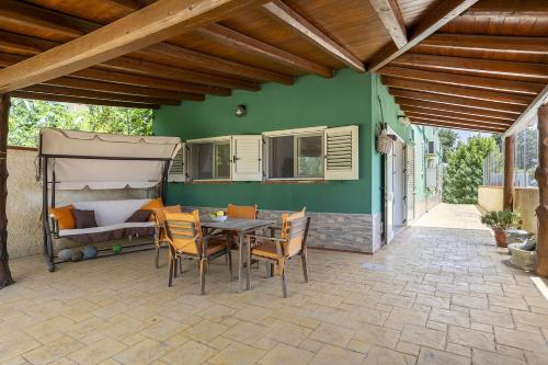 a patio with a table and chairs and a bed at Pi la via di Selinunte in Partanna