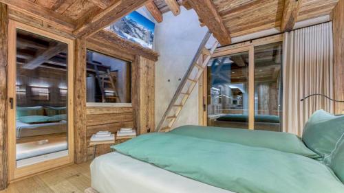 Un dormitorio con una cama verde y una escalera. en Akchalet Akaroa, en Livigno