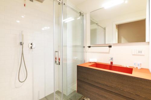 a bathroom with a shower and a red sink at Contempora Apartments - Visconti di Modrone in Milan