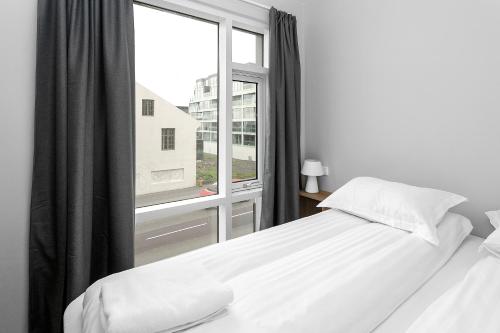 a bedroom with a bed and a large window at Central Studio Apartment in Reykjavík
