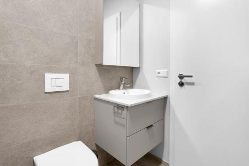 uma casa de banho com um lavatório branco e um WC. em Central Studio Apartment em Reiquiavique