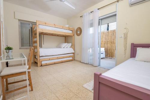 a bedroom with two bunk beds and a window at Mike's House Jerusalem in Jerusalem