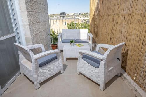 a patio with two chairs and a table on a balcony at Mike's House Jerusalem in Jerusalem