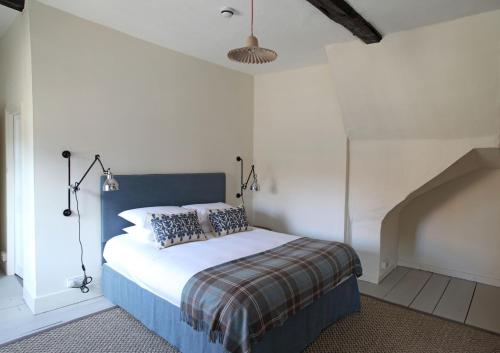 a bedroom with a bed with a blue headboard at Black Lion Hotel in Little Walsingham