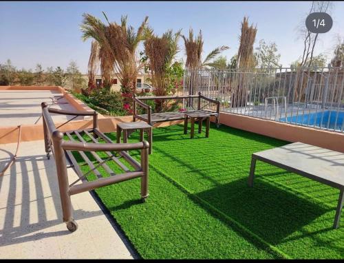 a yard with three benches and a swimming pool at منتجع تل الزيتون 