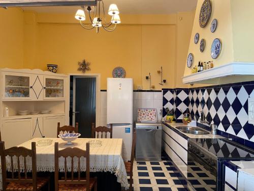 uma cozinha com uma mesa e um frigorífico branco em Casa Muriana em Alanís