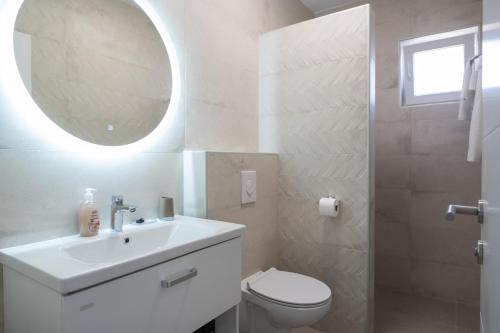 a bathroom with a sink and a toilet and a mirror at Villa Marta in Sukošan