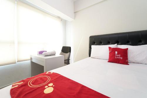 een slaapkamer met een rode deken op een bed bij RedLiving Apartemen Springlake Summarecon - Happy Rooms Tower Elodea with Netflix in Rawabugel