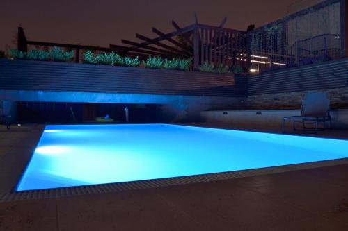 duży basen z niebieskim oświetleniem w pokoju w obiekcie Apartment Rezidence La w Pradze