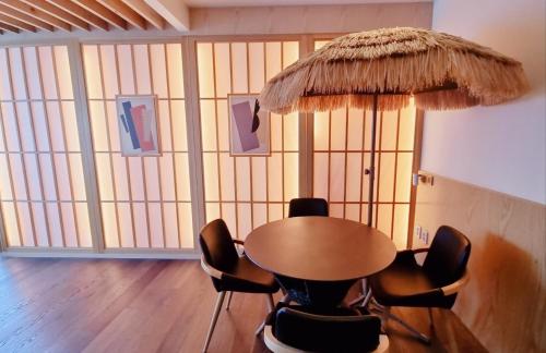 a table and chairs in a room with a large window at Gwanganli The Club Hotel in Busan