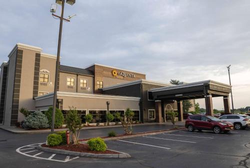 a building with a car parked in a parking lot at La Quinta by Wyndham Knoxville East in Knoxville