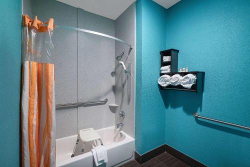 a blue bathroom with a shower and a sink at La Quinta by Wyndham Knoxville East in Knoxville