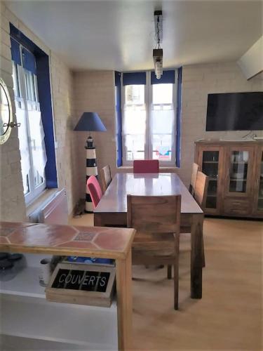 un salon avec une table et une télévision dans l'établissement Appt de charme en plein cœur historique, à Dives-sur-Mer