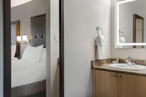 a bathroom with a sink and a bed at Days Inn by Wyndham Victoria Uptown in Victoria