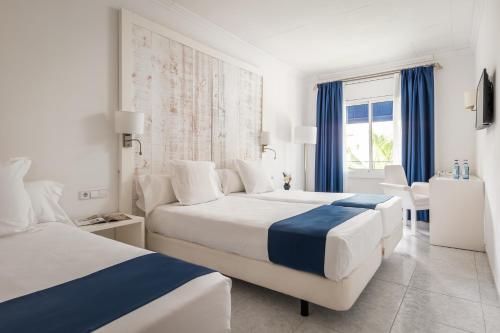 um quarto de hotel com duas camas e uma janela em Hotel Medium Sitges Park em Sitges