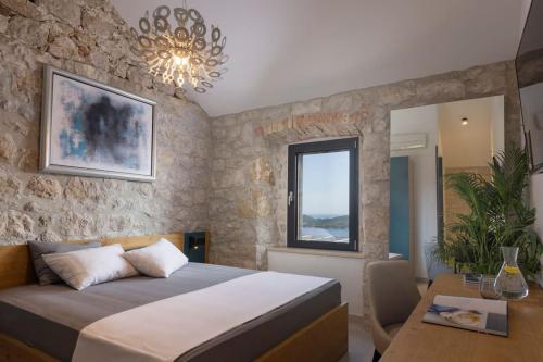 a bedroom with a bed and a table and a chandelier at Villa MaR-sea view,private pool in Orasac