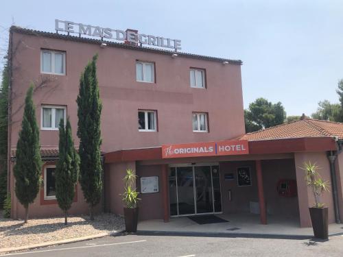 a pink building with a sign that reads the hamnsics hotel at The Originals City, Le Mas de Grille, Montpellier Sud in Saint-Jean-de-Védas
