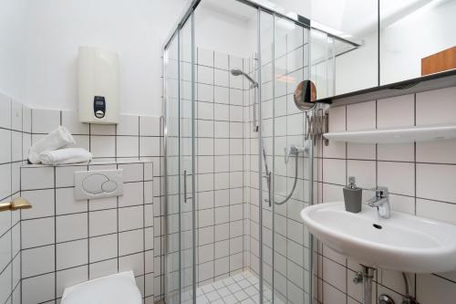 ein Bad mit einer Dusche und einem Waschbecken in der Unterkunft Adrian 3 in Westerland