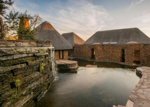 a pool of water in front of two buildings at Tala Collection Game Reserve in Silverton