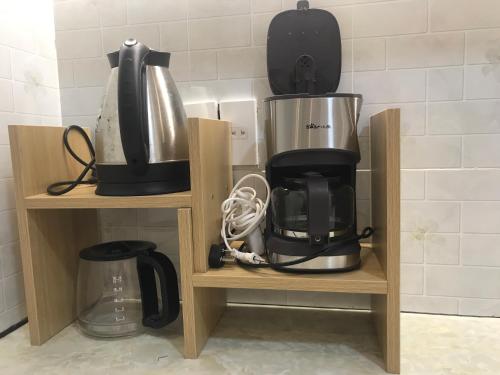 a coffee maker and a blender on two wooden shelves at Whispering Pines Dalat (Thông Thì Thầm ĐL) in Da Lat
