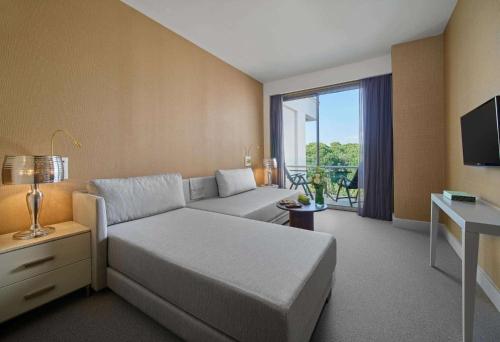 a hotel room with a bed and a balcony at Maxx Royal Belek Golf Resort in Belek