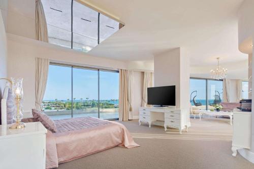 a bedroom with a bed and a large window at Maxx Royal Belek Golf Resort in Belek