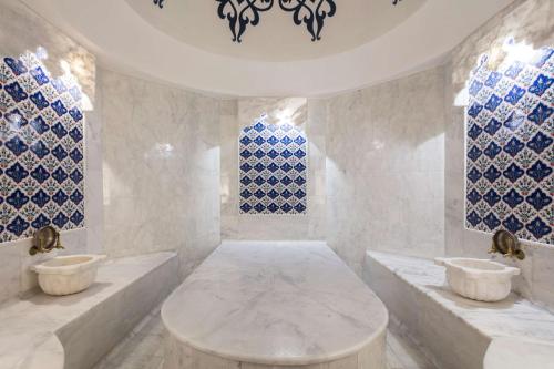 a bathroom with two sinks and blue and white tiles at Maxx Royal Belek Golf Resort in Belek