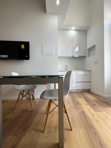 cocina con escritorio y 2 sillas en una habitación en Glass Boutique - Rooms & Suites, en Marinha Grande