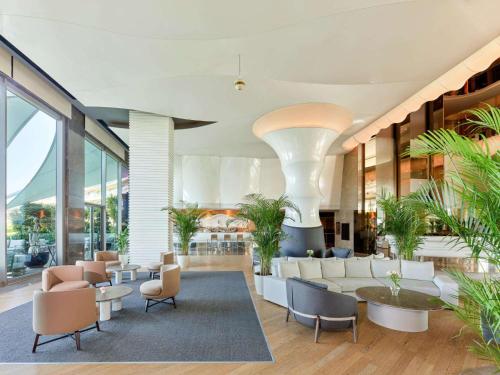 a lobby with couches and tables and plants at Maxx Royal Belek Golf Resort in Belek