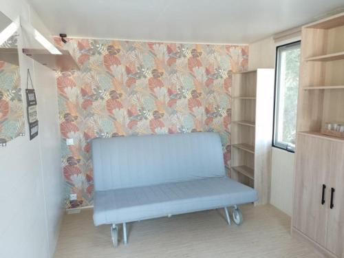 a blue bench in a room with floral wallpaper at camping bonneval in Jaujac