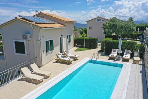 a villa with a swimming pool and a house at Lefkogea Villas & Apartments in Tsoukaladhes