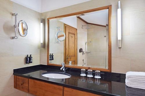 a bathroom with a sink and a large mirror at Parkhotel Oberstaufen in Oberstaufen