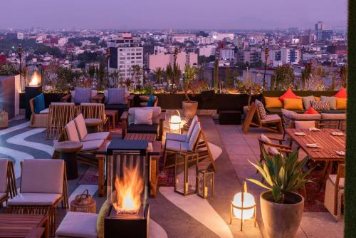 um pátio no último piso com uma fogueira, mesas e cadeiras em Andaz Mexico City Condesa - A Concept by Hyatt em Cidade do México