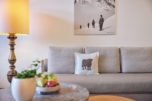 a living room with a couch with a pillow on it at Parkhotel Oberstaufen in Oberstaufen