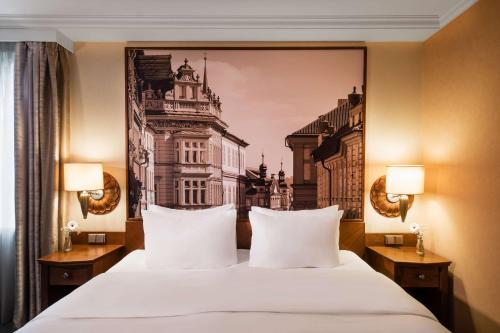 ein Hotelzimmer mit einem großen Bett mit weißen Kissen in der Unterkunft Lindner Hotel Prague Castle, part of JdV by Hyatt in Prag