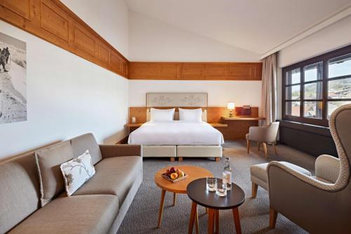 a hotel room with a bed and a couch at Parkhotel Oberstaufen in Oberstaufen