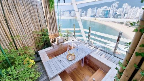 a balcony with a table and a view of the beach at Gwanganli The Club Hotel in Busan