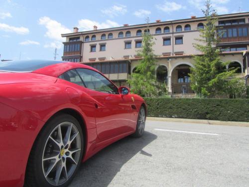 ein rotes Auto, das vor einem Gebäude parkt in der Unterkunft Hotel Spa Balfagon in Cantavieja